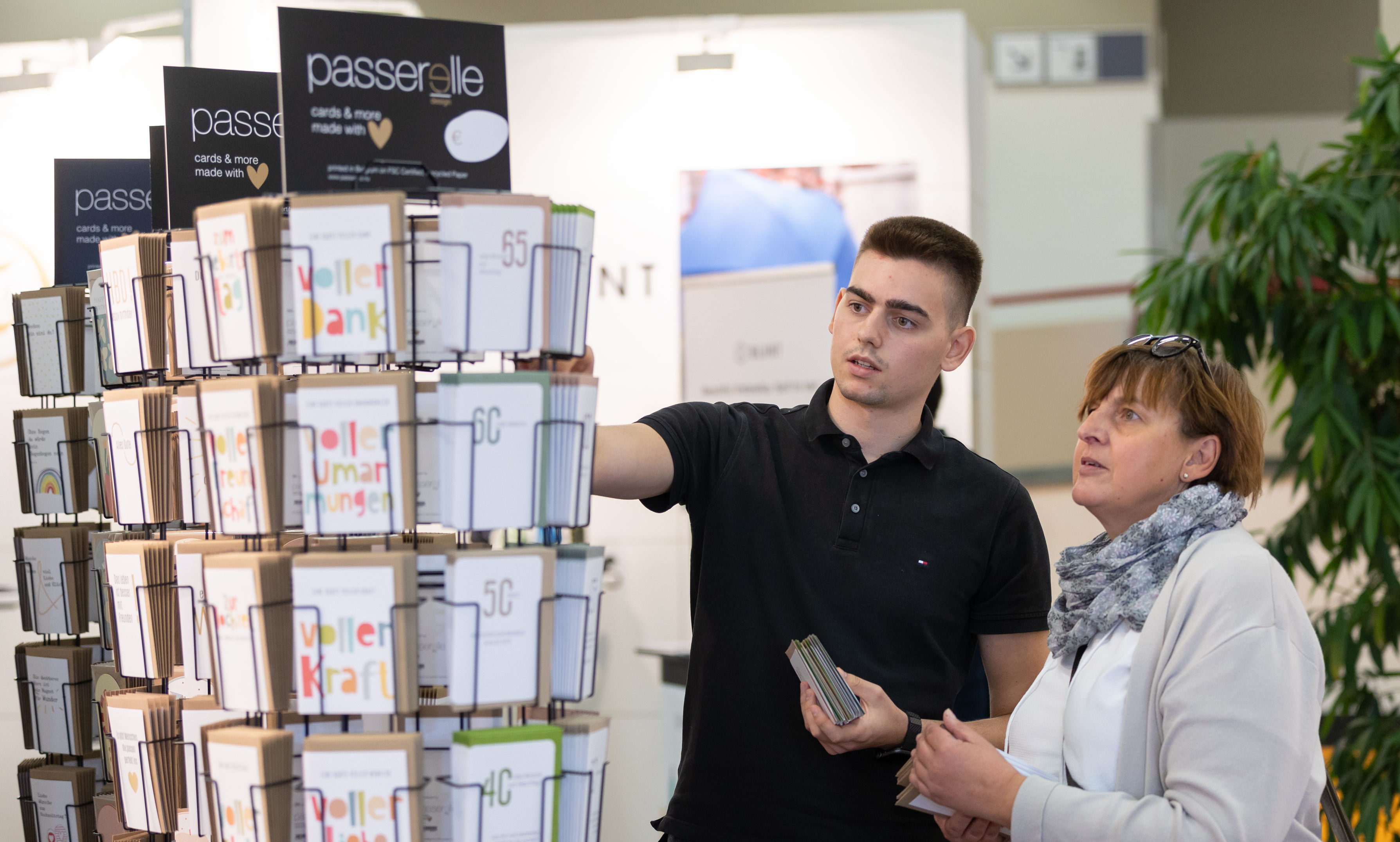 Sales talk at the Passerelle Design greeting card stand.